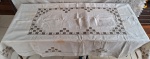 ILHA DA MADEIRA- Toalha em linho, na cor marrom, bordados geométricos, florais em quadrados escalonados. Acompanha 12 guardanapos. Med. 265 x 175 cm, guardanapos 41 x 41cm. Com manchas de guardados.