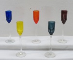 VACHERON - Cinco (05) taças para licor em cristal de cores variadas, lapidadas com caneluras, base e haste translúcida.  Marcada. Med. 16 cm alt x 3 cm diâmetro.