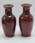 Par de antigos vasos em porcelana oriental, dita sangue de boi. Marcado na base com selo azul. Ambos com restauro na base ( colados). Med. 21 x 9 cm.