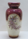 Elegante vaso em porcelana, na cor marfim, decorado com florais, guirlandas em dourado. Base e borda na cor grená, década 60. Med. 32 x 14 cm diâmetro. Marcado e numerado na base. Mínimos desgastes na policromia.