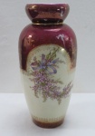 Elegante vaso em porcelana, na cor marfim, decorado com florais, guirlandas em dourado. Base e borda na cor grená, década 60. Med. 32 x 14 cm diâmetro. Marcado e numerado na base. Mínimos desgastes na policromia.
