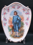 SALER-Placa decorativa em porcelana moldada na pasta, imagem do menino azul de Thomas Gainsborough, bordas relevadas com rosáceas e detalhes a ouro. Assinada Gainsborough Mulder e Zoon Amsterdam- Holand. Med. 24 x 18 cm.