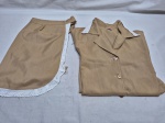 Conjunto feminino é composto por uma blusa de botões e uma saia correspondente, ambas na cor bege com detalhes em renda branca na gola e na lateral. Tam: 40