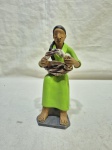 Escultura figurativa em terracota policromada representando mulher sentada com cesto, acabamento artesanal de estilo popular. Medindo 17cm de altura.