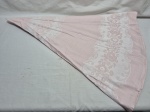 Toalha de mesa de tecido rosa com detalhes em renda branca nas bordas, apresentando um padrão floral ou de damasco.  Medindo 160cm de diâmetro.