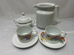 Lote de leiteira. 2 xícaras de chá (pires adaptado) e açucareiro em porcelana. Medindo a leiteira 16cm de altura.