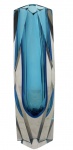 Vaso em cristal Moser  tom azulElegante vaso em cristal Moser, corpo facetado com núcleo em azul profundo envolto por cristal incolor, criando sofisticado efeito óptico. Lapidação precisa, linhas geométricas e excelente transparência, característica da tradicional manufatura tcheca. Peça de destaque para colecionadores e decoração refinada. Ótimo estado geral. Mede 18 cm.