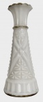 Vaso em vidro opalino branco, corpo facetado com relevo geométrico e motivos florais em moldagem prensada. Boca ondulada em forma de flor e base circular escalonada. Peça de estilo clássico, provável produção europeia do início do século XX. Apresenta marcas do tempo e desgaste compatíveis com a idade. Mede 15cm de altura x 6,5cm de diâmetro.