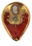 VENEZA - Gracioso porta alianças em cristal veneziano na tonalidade rubi, com rica decoração aplicada em douração, relevo floral policromado e medalhão com perfil clássico em cameo. Formato orgânico com borda modelada. Apresenta sinais do tempo e leves desgastes na douração. Mede 10cm.
