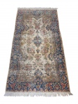 Tapete persa estilo Nain, de fina manufatura, em lã (possíveis detalhes em seda), decorado com medalhão central e rica composição floral em tons de azul e marfim.Peça elegante, de trama delicada e alta densidade.Meados séc. XIX. Desgaste do tempo.Medidas: 228 x 118 cm.