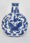 China. Vaso em porcelana esmaltada, decorado em tonalidade azul sob fundo branco, apresentando rica composição com borboletas estilizadas em diferentes tamanhos, distribuídas de forma harmoniosa pelo bojo. Gargalo com ornamentos geométricos e faixa decorativa. Manufatura no verso. Medindo; 27 x 21 cm. 
