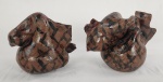Par de esculturas em cerâmica, modeladas manualmente em barro com acabamento rústico e pintura em tons terrosos com grafismos. Peças de caráter decorativo, vinculadas à arte popular. Apresentam marcas naturais do processo artesanal. Medidas: 15 x 12 cm (cada). Um com quebra. 