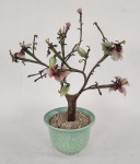 Vaso em porcelana esmaltada na cor verde do estilo celadon com árvore decorativa estilo bonsai, com estrutura metálica e aplicação de pedras ornamentais em formato de flores.  Apresenta perdas, com pedras soltas e quebradas, necessitando recomposição/restauro. Altura: 28 cm. 