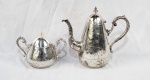 Bule e açucareiro com tampa, em metal espessurado à prata, ricamente decorados com gravuras florais de inspiração oriental (motivo bambu). Apresentam alças ornamentadas e bicos longilíneos de desenho elegante. Período provável: final do século XIX / início do século XX. Restauro na alça do bule, apresentam sinais de uso, oxidação e desgaste do banho. Medindo: 24 x 26 cm e 15 x 20 cm. 