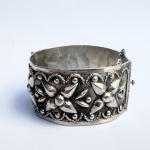 Antigo bracelete produzido em alpaca decorado com flores em relevo. Med do diâmetro 6,5 cm e altura 3,5 cm. 