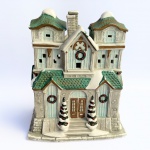 Decorativa casa de coleção confeccionada em biscuit em policromia com riqueza de detalhes.Janelas vazadas. Med 18x15,5x11,5 cm. 