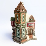 Decorativa casa de coleção confeccionada em biscuit em policromia com riqueza de detalhes. Janelas vazadas. Med 20x14 cm.