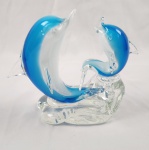 Escultura decorativa de Murano representando casal de golfinhos na tonalidade azul e
translúcido. Técnica de sopro manual, medindo 18x21cm.