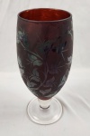 Vaso em pasta de vidro na tonalidade rubi com estamparia floral. Possui tinta no
interior não visível na parte exterior, possivelmente para esconder alguma falha na
pintura em nada atrapalhando a beleza da peça, medindo 25x10cm.