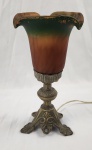 Luminária de mesa em bronze trabalhado com cúpula em pasta de vidro
representando cúpula de flor, medindo 54cm.