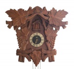 Antigo Relógio cuco em madeira nobre, da manufatura REI, decorado com cachos de uvas e folhas de parreira, Altura: 45 cm; largura: 42 cm; profundidade:15 cm; com pássaro na parte superior. (não acompanha pesos) necessita revisão, faltando uma folha na parte de cima.