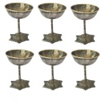 Antigo conjunto com 6 taças em metal espessurado a prata, com fina haste, sobre base decorada com folhas em relevo; Medindo 10 X 8 cm ( necessita de limpeza).