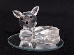 SWAROVSKI - Linda e graciosa escultura de cristal austríaco em forma de `  bambi ` com perfeitos detalhes e lapidação vem acompanhado de uma base espelhada redonda; medindo  4,5  x 3 cm.