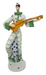 FRAURE ULT - Escultura art déco representando Pierrô tocando violão, confeccionada em porcelana alemã vitrificada e policromada nas cores verde e branca, manufatura kunstabteilung ; medindo 27 x 18 cm.