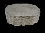 Antiga e imponente caixa com tampa, confeccionada em metal espessurado a prata, apresentando elegante formato recortado e rica decoração em relevo e gravações ornamentais de inspiração floral e arabesca. Tampa articulada com acabamento interno liso e exterior finamente trabalhado. Medidas: 18 x 23 x 7,5 cm.