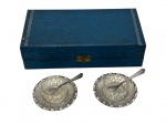 Elegante estojo contendo conjunto para mesa composto por saleiro e pimenteiro em vidro lapidado, acompanhados de suportes e colheres em metal prateado. Acondicionados em estojo original.