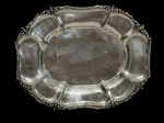 Elegante centro de mesa confeccionada em metal espessurado a prata, borda ricamente ornamentada com elementos em relevo e acabamento torcionado. Medidas: 28 x 22 x 5,5 cm.