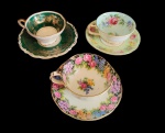 EUROPA. Delicado conjunto de xícaras para café em porcelana decorada com motivos florais policromados e detalhes dourados, composto por 3 xícaras acompanhadas de seus respectivos pires.