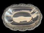 Centro de mesa em metal espessurado a prata, com borda ricamente cinzelada. Medidas: 33 x 23 x 4,5 cm.