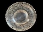 Antiga salva em metal espessurado a prata, ricamente ornamentada com delicado trabalho vazado em motivos de parreiras, folhas e cachos de uvas, contornada por elegante borda perlada. Medidas: 26,5 x 2,5 cm.