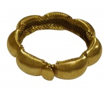Elegante bracelete de bijuteria em metal dourado, apresentando design volumoso e contemporâneo com segmentos canelados em composição articulada. Peça de marcante presença estética, com acabamento texturizado e fecho funcional, ideal para compor produções sofisticadas e de estilo vintage.