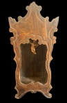 Antigo oratório de parede em madeira entalhada, apresentando elegante decoração recortada em estilo barroco/rococó. Interior em formato de nicho, contendo pequena imagem de anjo policromado. Med.: 69 x 29 x 14 cm.