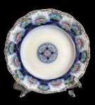 Antigo prato decorativo em porcelana inglesa, manufatura J & G Meakin, padrão Balmoral, com rica decoração policromada em motivos florais e arabescos em tons de azul cobalto, verde e rosa, realçados por filetes dourados. Borda recortada de elegante acabamento, apresentando marca da manufatura na base, medida: 20 cm.