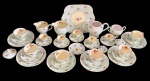 Foley China, Inglaterra. Conjunto em porcelana inglesa decorado com delicados motivos florais e filetes dourados, composto por prato grande, duas leiteiras, dois açucareiros, cinco xícaras de café com pires (havendo um pires avulso) e seis xícaras de chá com pires. Peças apresentam marcas do tempo compatíveis com o uso e antiguidade, sendo que o prato maior possui fio de cabelo. Medidas: prato 24 x 21 cm; leiteira maior 11 x 10 x 15 cm; leiteira menor 13 x 9 x 9,5 cm; açucareiro maior 11 x 18 x 14 cm; açucareiro menor 10,5 x 13,5 x 9,5 cm.