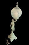 Luminária em petit bronze com figura feminina sustentando cúpula em vidro fosco decorado em relevo floral, apresentando desgastes na pátina compatíveis com o tempo. Medidas: 71 x15 x 15 cm.