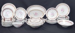 Schmidt, Brasil. Serviço para jantar em porcelana vitrificada e esmaltada na cor branca, decorado com orquídeas, faixa em tom vinho e detalhes em ouro. Composto por doze pratos rasos, onze pratos fundos, doze pratos para sobremesa, cinco travessas, uma sopeira, um prato para arroz e uma molheira. Manufatura no verso. Observação: Um prato raso com bicado.
