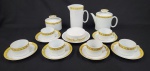 Renner Porcelana Medalhão, Porto Alegre, Brasil. Jogo para chá em porcelana esmaltada na cor branca, decorado com faixa floral em tons de amarelo e detalhes em douração. Composto por um bule, um açucareiro, uma manteigueira, uma leiteira e seis xícaras com seus respectivos pires. Manufatura no verso.
