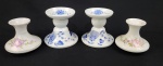 Quatro castiçais em porcelana decorada, sendo um com restauro visível, peças com pinturas florais e azuis, marcas diversas no verso, altura do maior 10 cm.um com restauro.