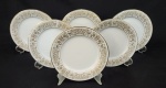 Noritake, Japan. Seis pratos para sobremesa em porcelana japonesa esmaltada na cor branca, modelo Raphael, com rica decoração de flores, volutas e filetes em ouro. Manufatura no verso. Medindo: 18 cm.