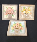 Oficina de Agosto (Tiradentes/MG) 3 quadros decorativos em madeira rustica, medindo 32 x 32 cm cada, com relevo entalhado e pintura floral em vaso, moldura rústica patinada, apresentando sinais de uso.