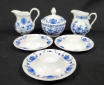 Hutschenreuther, Germany. Gracioso conjunto, composto por 2 leiteiras, três porta-ovos e um açucareiro em porcelana alemã esmaltada, padrão cebolinha, em tons de azul e branco. Manufatura no verso.