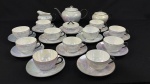 Czecho-Slovakie. Aparelho de chá em porcelana branca esmaltada, com acabamento iridescente e delicado filete em preto, composto por onze xícaras com seus respectivos pires, um bule, um açucareiro, uma cremeira e uma manteigueira. Manufatura no verso. Observação: Conjunto com sinais de uso, 2 xícaras e tampa do açucareiro com fio de cabelo/bicados.