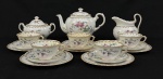 Tuscan, England. Aparelho de chá em porcelana bone china esmaltada na cor branca, decorado com motivos de flores, folhas e pássaros. Composto por um bule, um açucareiro, uma leiteira, cinco xícaras com seus respectivos pires e cinco pratos para bolo. Manufatura no verso. Altura do bule: 17 x 23 cm. Observação: Conjunto com sinais do tempo, sendo: tampa do açucareiro colada, dois pratos, 2 pires e uma xícara com fio de cabelo; uma xícara com lascado na borda; xícaras com manchas.