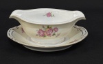 Kyoto China, Occupied Japan. Uma molheira em porcelana japonesa esmaltada, com decoração floral e detalhes em douração. Manufatura no verso. Medindo; 7 x. 21 cm.