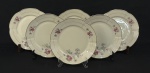 Chodziez, Polônia. Seis pratos rasos em porcelana esmaltada no tom marfim, decorados com delicados motivos florais e filetes dourados. Manufatura no verso. Medindo: 25 cm.