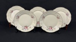 Chodziez, Polônia. Cinco pratos para sobremesa em porcelana esmaltada no tom marfim, decorados com delicados motivos florais e filetes dourados. Manufatura no verso. Medindo: 20 cm. Um com bicado.